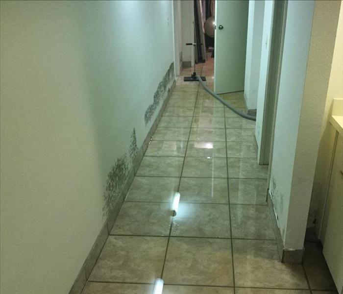 standing water reflecting off a tile floored hallway