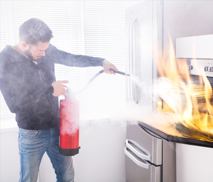 man extinguishing fire in oven
